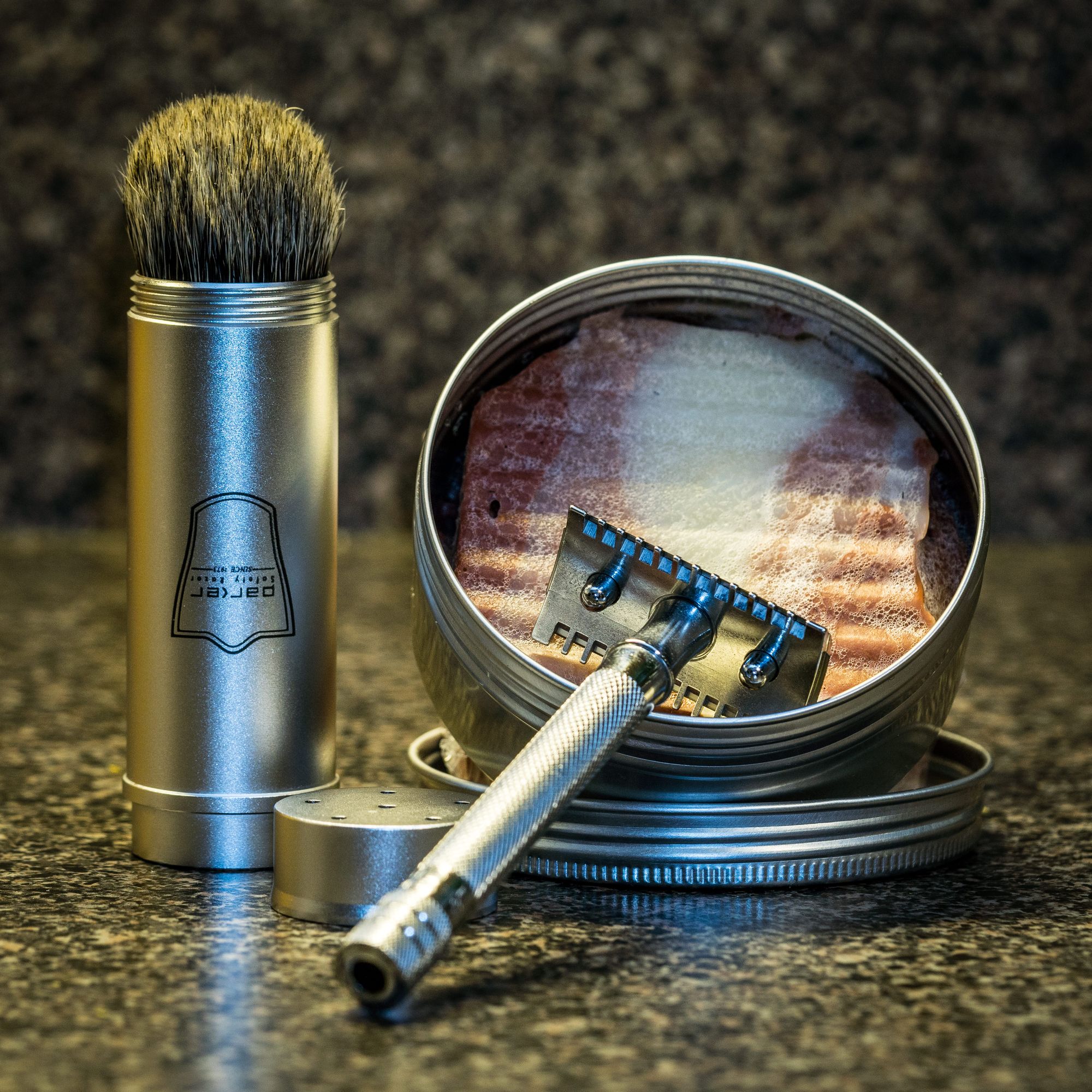 A travel shave brush, DE safety razor and tin of soap