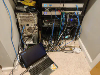 The NexDock plugged into a Raspberry Pi showing it can be used to administer servers. The picture shows the NexDock on the floor next to a number of servers and other 'enterprise' hardware that forms the foundation of my home network.
